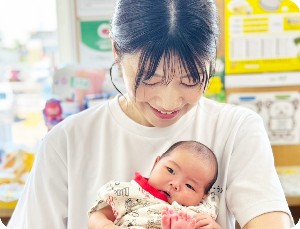 赤ちゃんを抱く笑顔のスタッフ